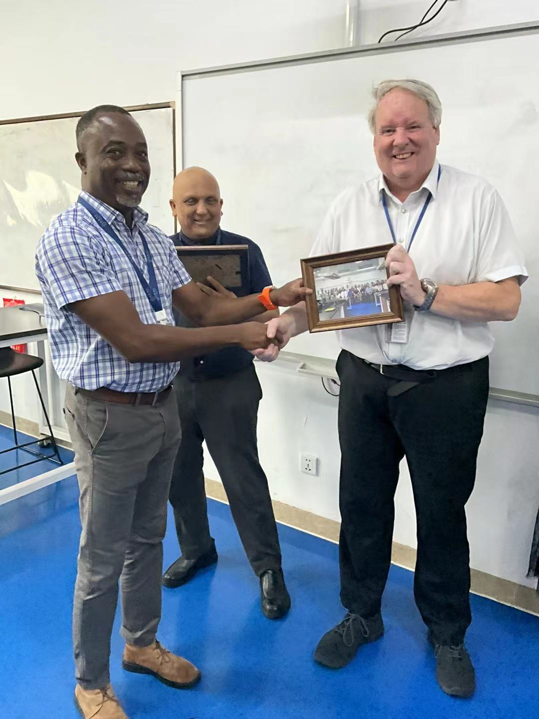 Andrew James Greaves receiving professional recognition from Kofi Akordor during a presentation
