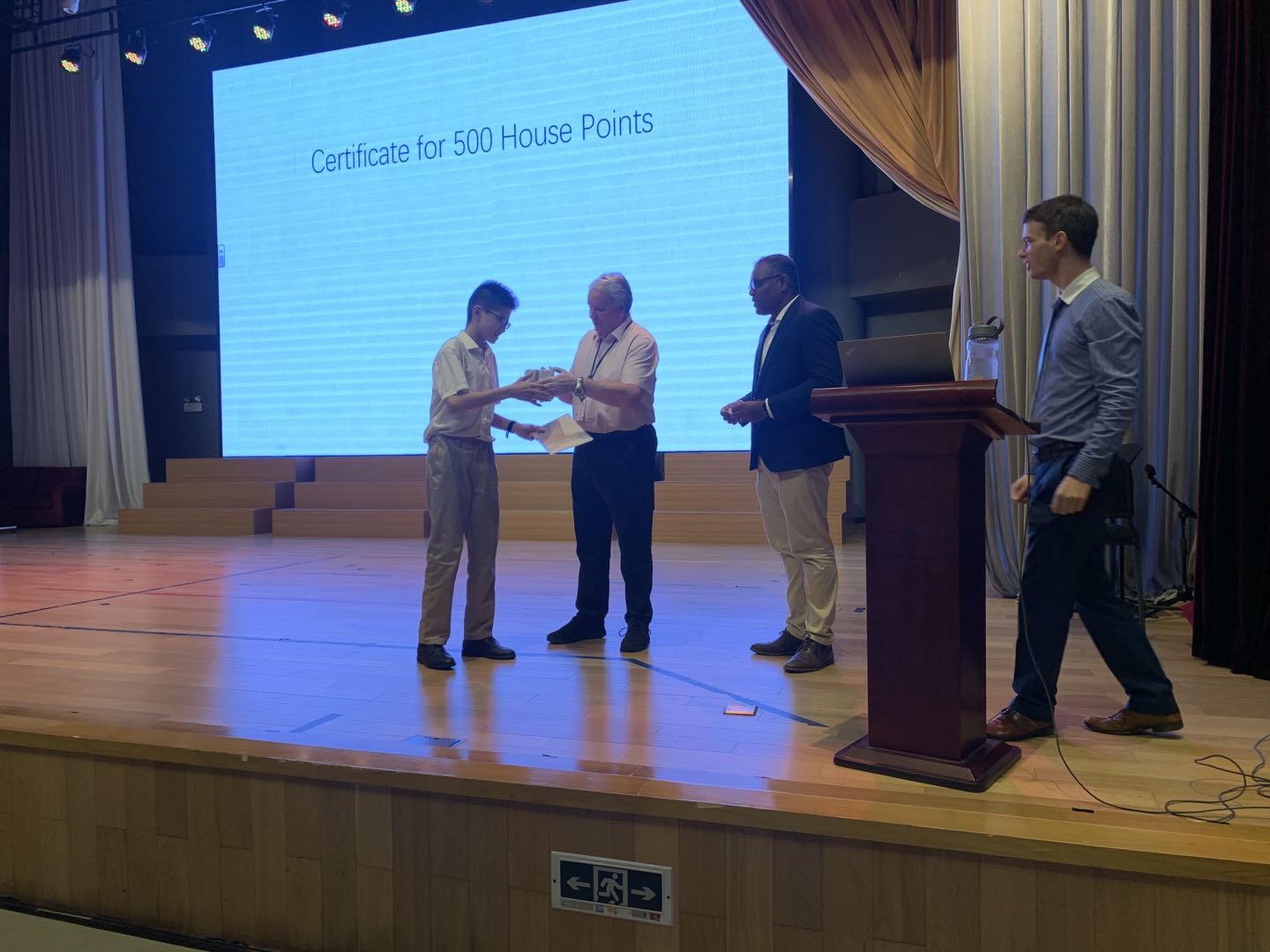 Presenting a certificate for 500 House Points during a whole-school awards ceremony